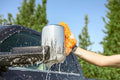 A person using the Extend-A-Reach microfiber car wash mitt to wash a truck mirror, providing safe, scratch-free vehicle cleaning