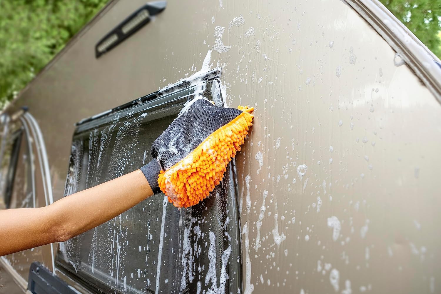 A person using the Extend-A-Reach orange chenille microfiber mitt to wash an RV wall for scratch-free car cleaning