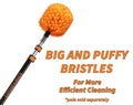 Close-up of the Extend-A-Reach cobweb duster with bright orange big and puffy bristles attached to a telescoping extension pole. Text on the image reads “BIG AND PUFFY BRISTLES For More Efficient Cleaning *pole sold separately,” highlighting the thick bristle design for better spider web removal on high ceilings and outdoor corners.