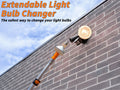 Extend-A-Reach extendable light bulb changer pole with suction cup attachment removing a high flood light bulb on an outdoor wall fixture. Text on image reads: ‘Extendable Light Bulb Changer – The safest way to change your light bulbs.