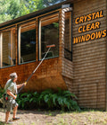 Man using Extend-A-Reach telescopic  pole with window squeegee to clean tall exterior house windows. Text on image reads: ‘Crystal Clear Windows.’