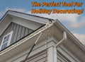 Extend-A-Reach utility hook attached to a telescoping extension pole, used for Christmas light hanging along a two-story house roofline. The image displays the text “The Perfect Tool for Holiday Decorating!”. This light hanging pole setup is ideal for hanging string lights using a telescopic extension pole or extendable pole with a utility hook for high-reach decorating.